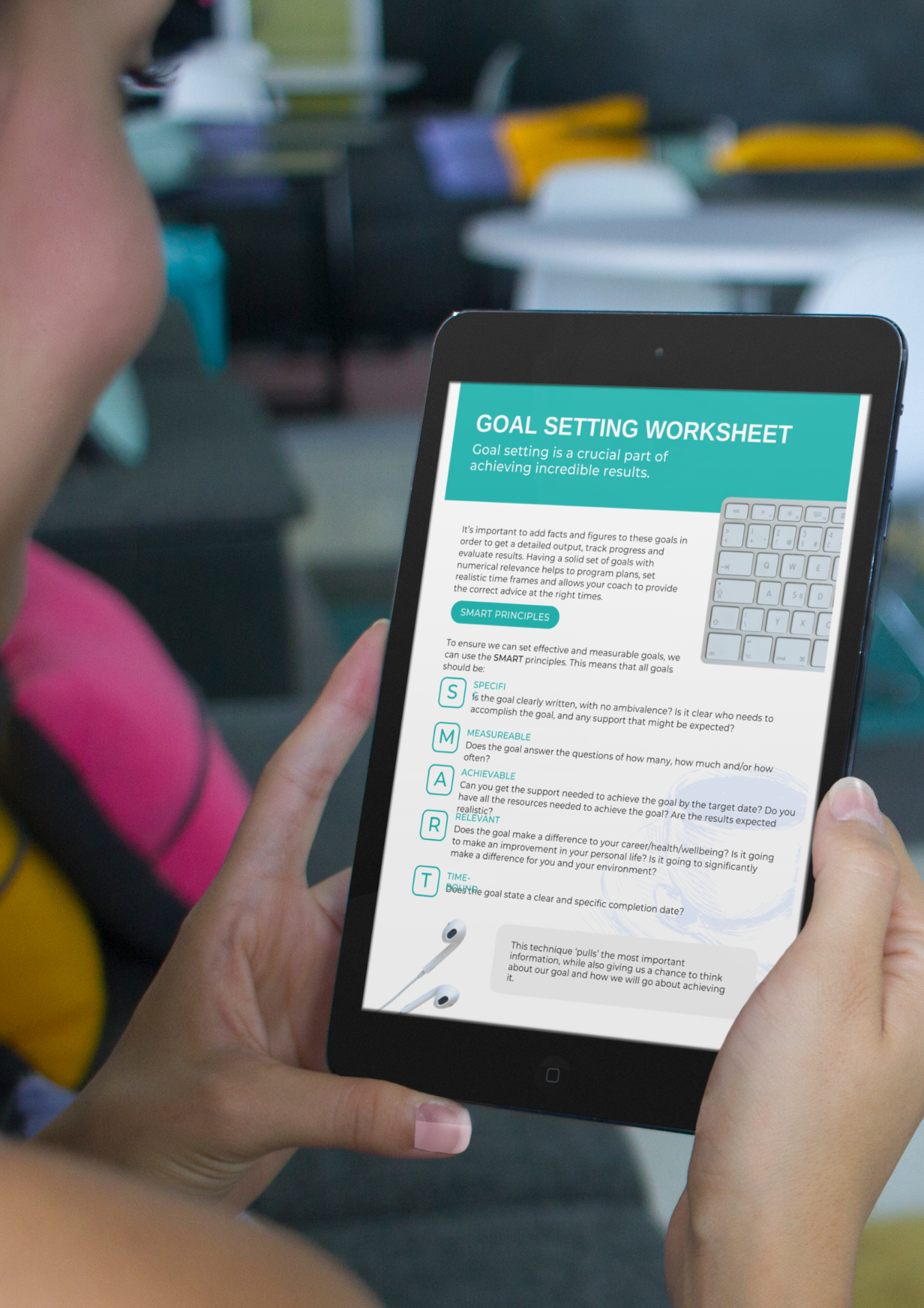 A person holding a tablet displaying a goal-setting worksheet with the title "GOAL SETTING WORKSHEET" and the message "Goal setting is a crucial part of achieving incredible results." Unlock Your Path to Lasting Health and Fitness.