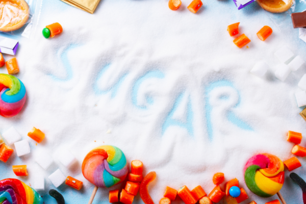 Effects of Sugar on the Brain: Colourful candies and sweets with the word “SUGAR” written in the background, highlighting sugar addiction and its effects on the brain.